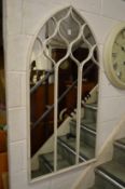 An arch shaped metal framed mirror.