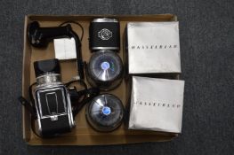 A Hasselblad 500c camera with two spare lenses, spare film back and a shutter release handle.