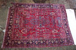 A large Persian carpet, red ground with floral decoration (damage to one corner) 11'10
