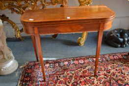 A George III mahogany and satinwood inlaid D shaped fold-over card table on tapering square legs.
