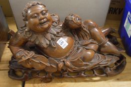 A good carved hardwood figure of reclining Hotei on a fitted stand.