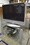 A Panasonic TV with TV stand, sky box etc.