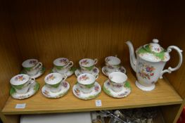 A parogan china coffee pot with eight matching cups and saucers.