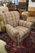 A check upholstered armchair on bun feet.