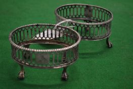 A pair of silver oval table salt frames.
