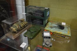 A small group of military vehicles, mostly boxed.
