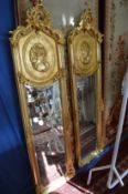 A pair of decorative gilt framed and narrow wall mirrors.