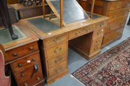 A Victorian oak pedestal desk with hinged writing surface.