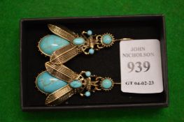 A pair of bug shaped earrings.