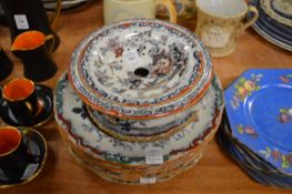An ironstone straining dish and stand and various similar plates and bowls.