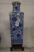 A Chinese blue and white tapering square vase on hardwood stand.