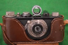 A Leitz Elmar 50mm camera with leather case.