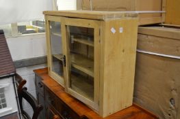 A pine two door hanging cupboard.