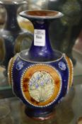 A Royal Doulton vase with moulded panels of flowers.
