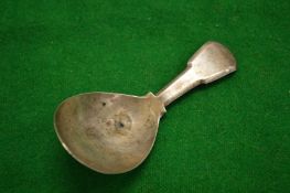 A silver caddy spoon.