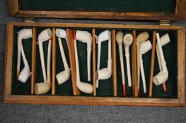 A good collection of clay pipes in a wooden storage box.