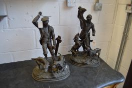 A pair of spelter figures depicting huntsmen and dogs.