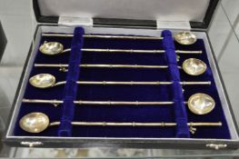 A set of six white metal combination cocktail spoons/straws in a fitted box.