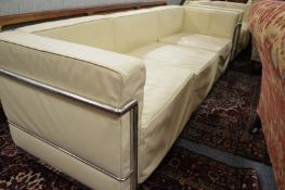 In the manner of Le Corbusier, a cream leather upholstered and chrome framed three seater settee.
