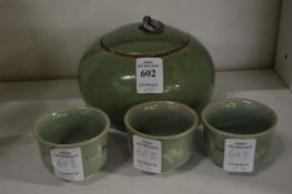 A Korean jar and cover with three similar small cups.