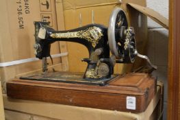 An early 20th century Singer sewing machine with parts, no box top.