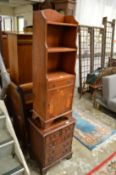 A narrow yew wood cupboard bookcase and a small chest of drawers.
