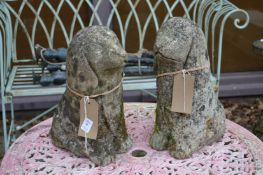 A pair of composite gardens ornaments modelled as seated dogs.