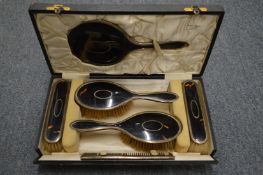 A cased set of silver mounted tortoiseshell dressing table items.