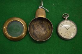 A pocket watch in a brass travelling case.