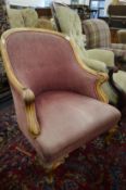 A Victorian crimson upholstered armchair with carved show wood frame.