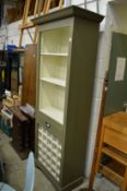 A green painted free standing kitchen unit with shelves, a draw and wine rack.