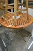 A teak and aluminium circular table.