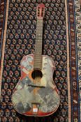 A classical guitar decorated with cut out news cuttings and photos of the Beatles etc.