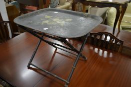 A floral painted Japanned tray on folding stand.