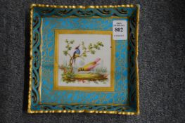 A Sevres square shaped porcelain dish, turquoise ground decorated with a panel of exotic birds.