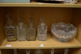 Four cut glass whisky decanters and a cut glass pedestal bowl.