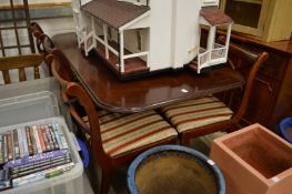 A mahogany twin pedestal extending dining table and six various chairs.