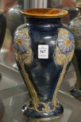 A Royal Doulton baluster shaped vase with moulded floral decoration.