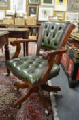 A green leather upholstered swivel armchair.
