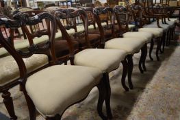 A set of five Victorian rosewood dining chairs with carved cresting rails and tie bars upholstered