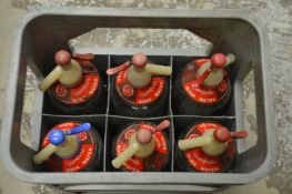 A crate of six soda siphons.