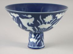 A CHINESE IMPERIAL BLUE GLAZE PORCELAIN STEM BOWL, decorated with white fish and flora, six-
