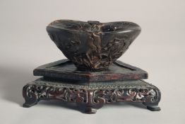 A 20TH CENTURY CHINESE SIMULATION HORN LIBATION CUP, together with a shaped hardwood stand