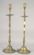A LARGE PAIR OF ISLAMIC BRASS CANDLESTICKS, each approx. 70cm high.