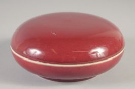 A CHINESE COPPER RED PORCELAIN CIRCULAR BOX AND COVER, six-character mark to base, 14.5cm diameter.