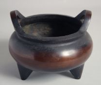 A SUPERB EARLY CHINESE BRONZE TRIPOD CENSER, possibly 17th/18th century, with twin handles, the base