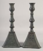 A PAIR OF PERSIAN QAJAR BRONZE CANDLESTICKS, with engraved decoration, 37cm high.