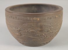 AN UNUSUAL CHINESE YIXING PLANT POT, with relief decoration of dragon and phoenix, 17.5cm diameter.
