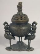 A CHINESE BRONZE CENSER AND COVER, with relief cranes and dragons, 25cm high.