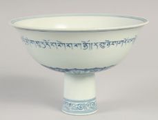 A CHINESE BLUE AND WHITE PORCELAIN STEM BOWL, the exterior with a band of characters, the interior